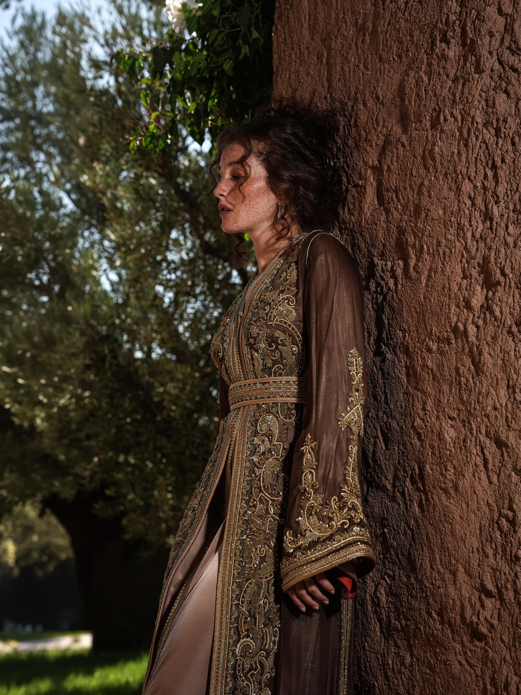 Bronze Reverie lamé organza Moroccan kaftan with gold embroidery, worn open over a champagne dress