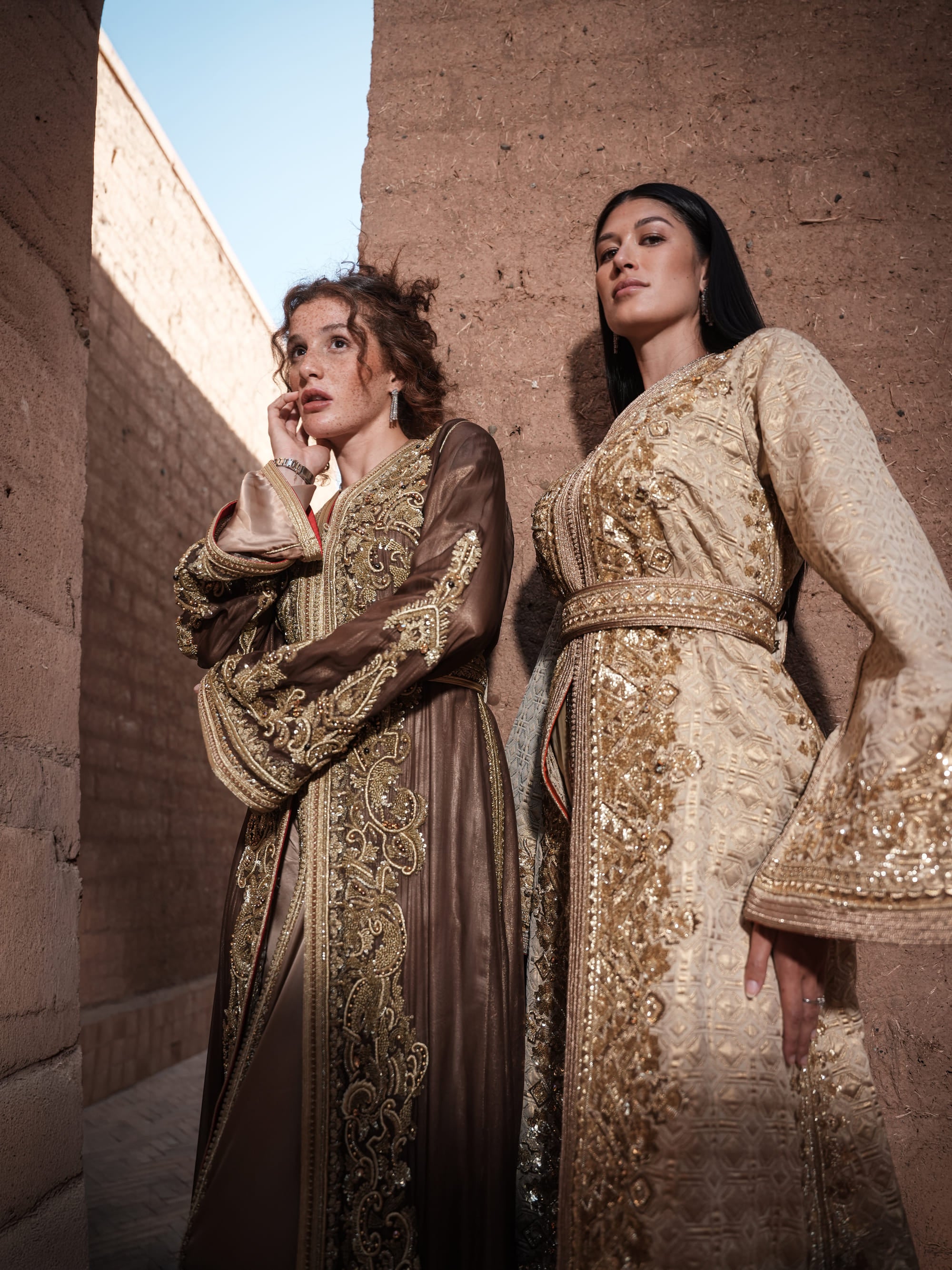 Alabaster Aria quilted ivory brocade Moroccan kaftan with gold sequin embroidery and belted waist, shown alongside a second look
