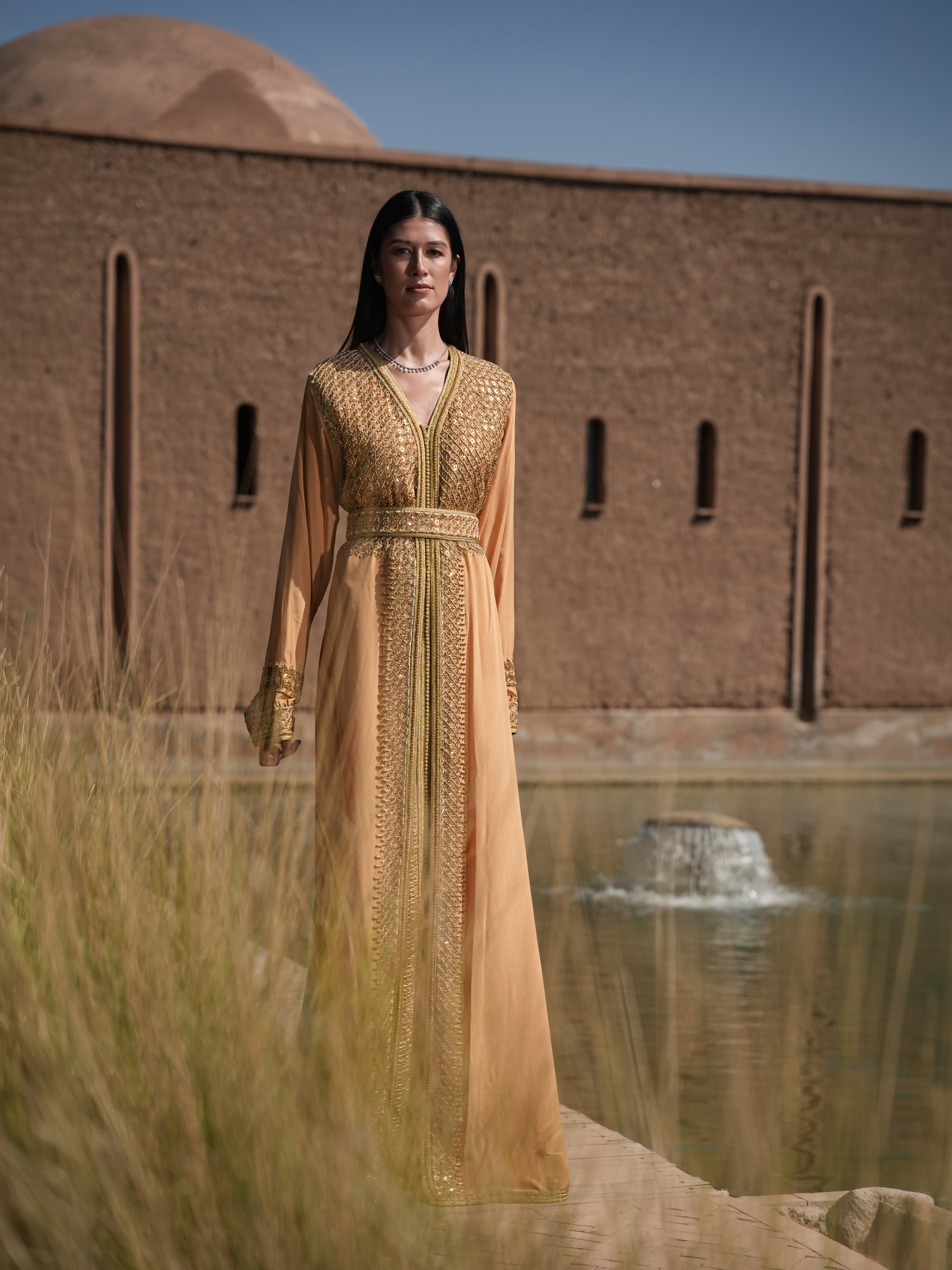 Amber Vigil apricot crepe Moroccan kaftan with a gold sequin mesh plastron at the neckline, full-length view