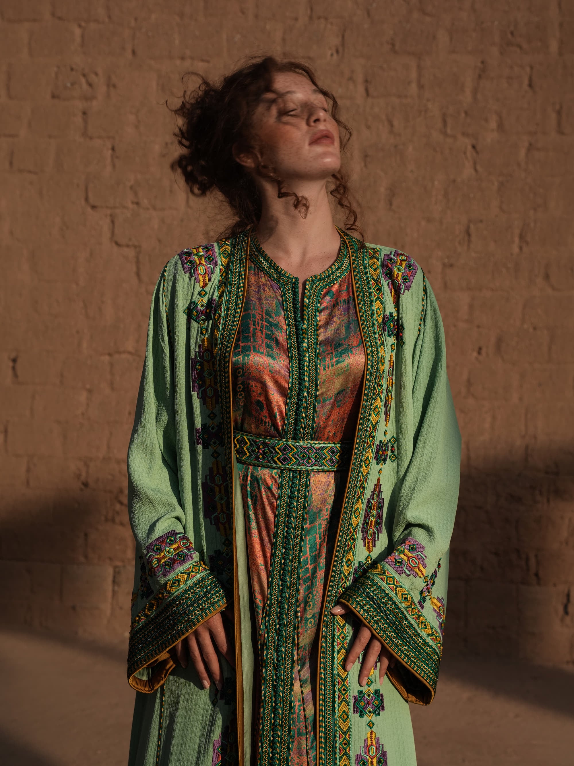 Anise Pavilion anise green Moroccan kaftan with Berber braid trims over a printed dress