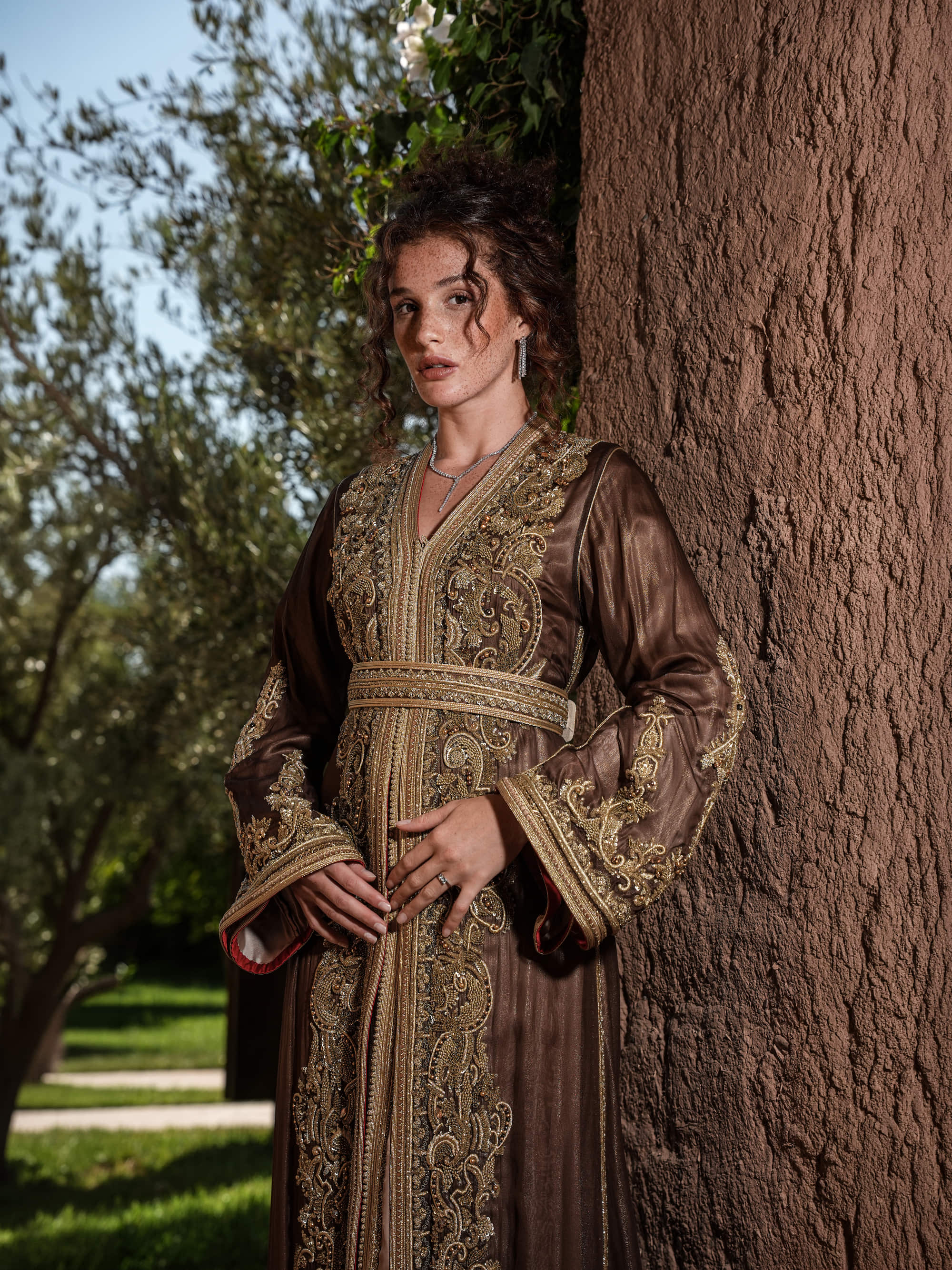 Bronze Reverie lamé organza Moroccan kaftan with gold embroidery, worn open over a champagne dress