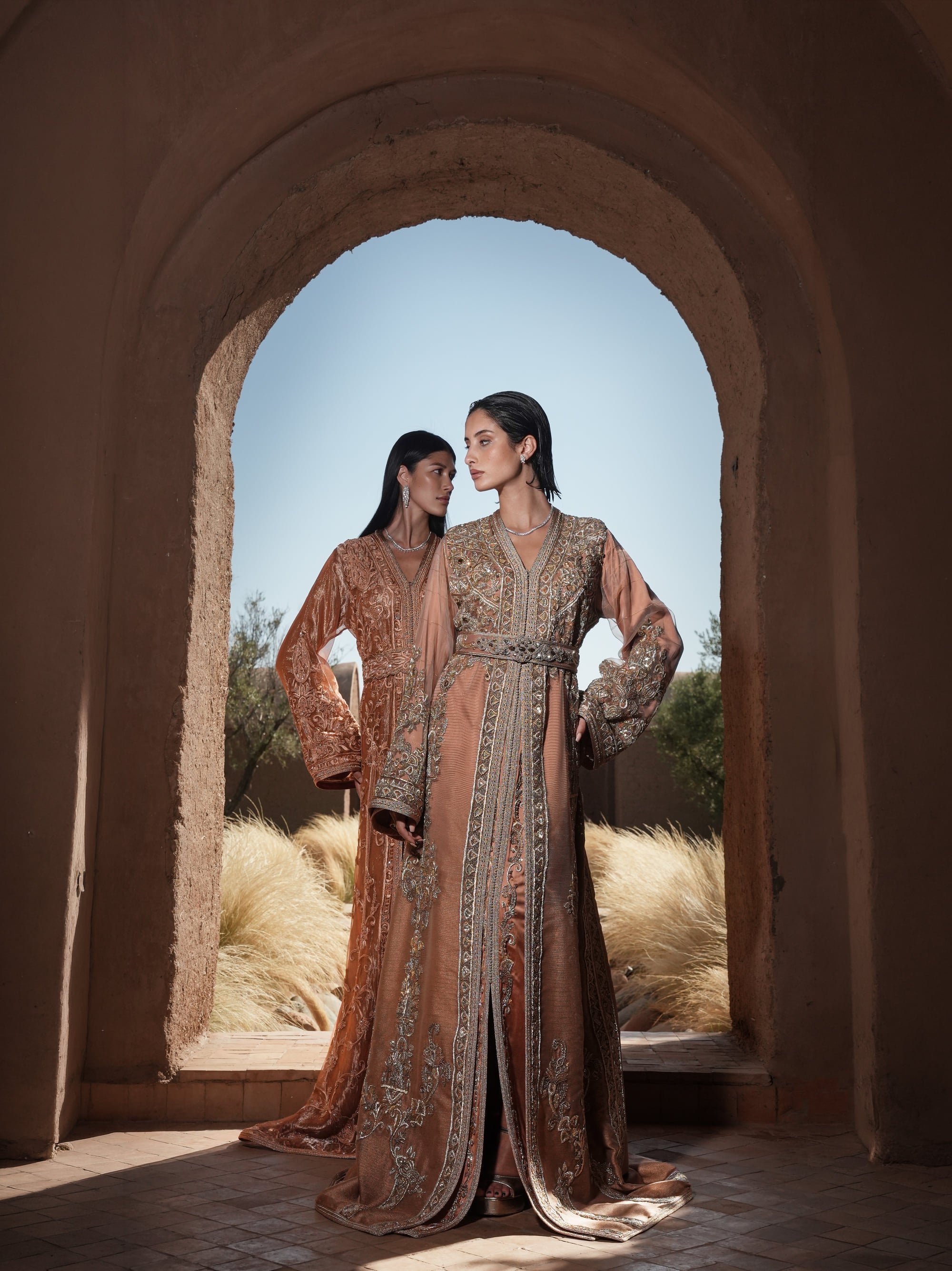 Copper Solstice devoré copper velvet Moroccan kaftan with tone-on-tone embroidery, shown alongside a second look