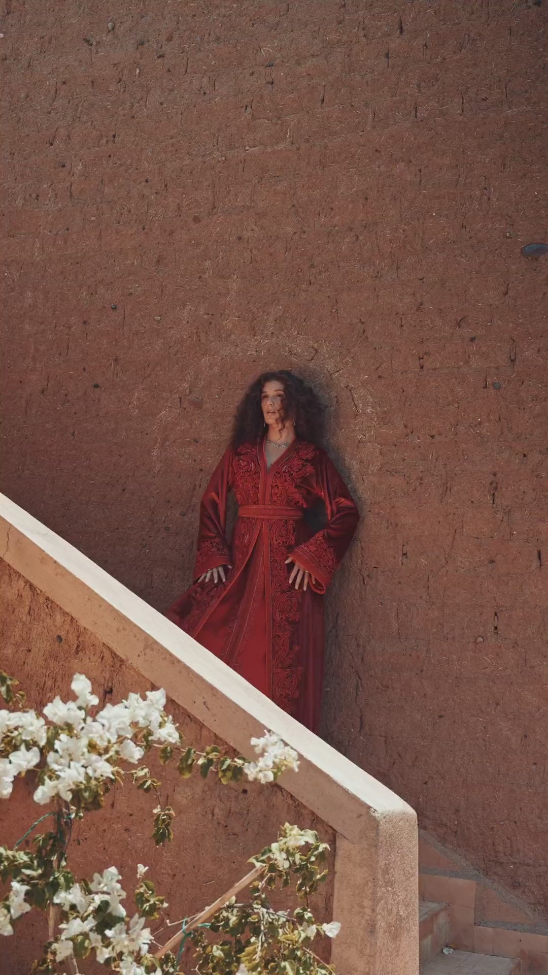Carmine Cadence red crepe Moroccan kaftan with sequined paisley embroidery, braided belt and flared sleeves, in motion