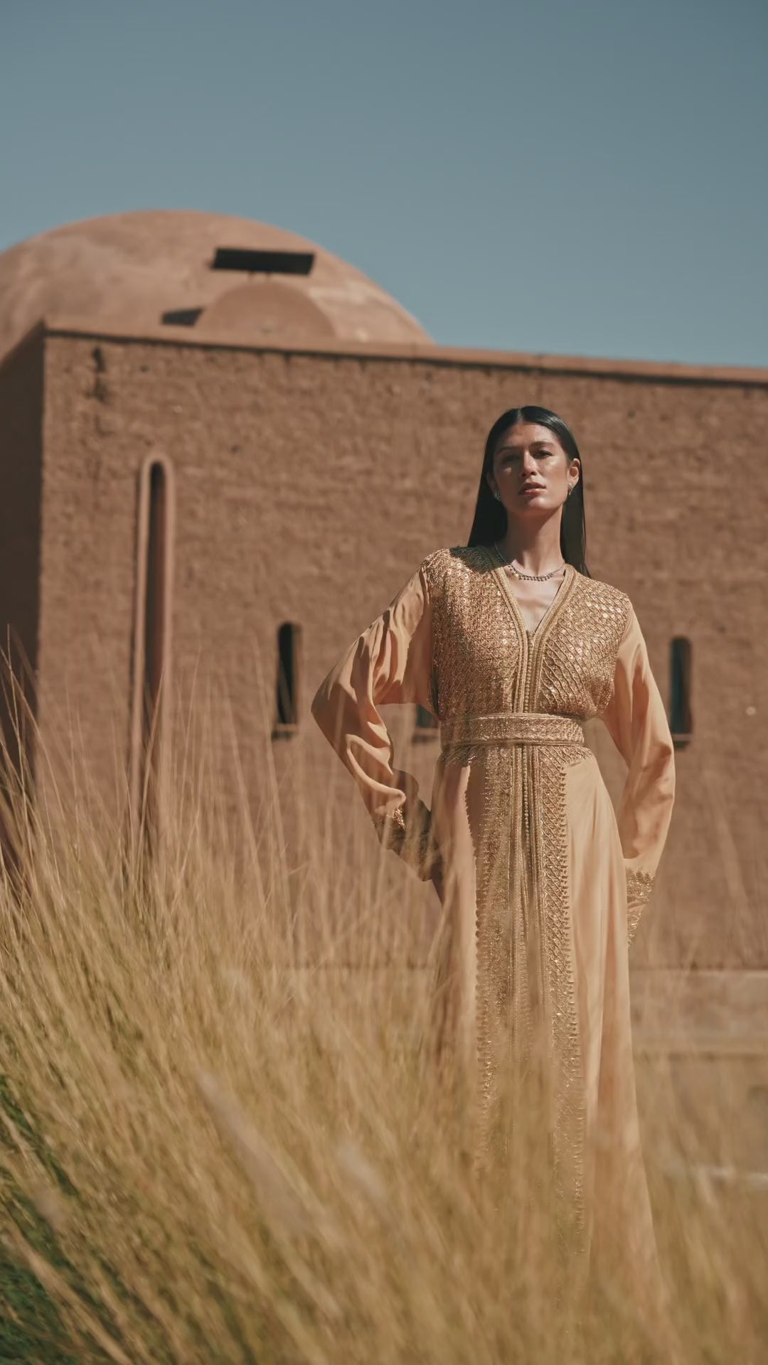 Amber Vigil apricot crepe Moroccan kaftan with a gold sequin mesh plastron at the neckline, in motion