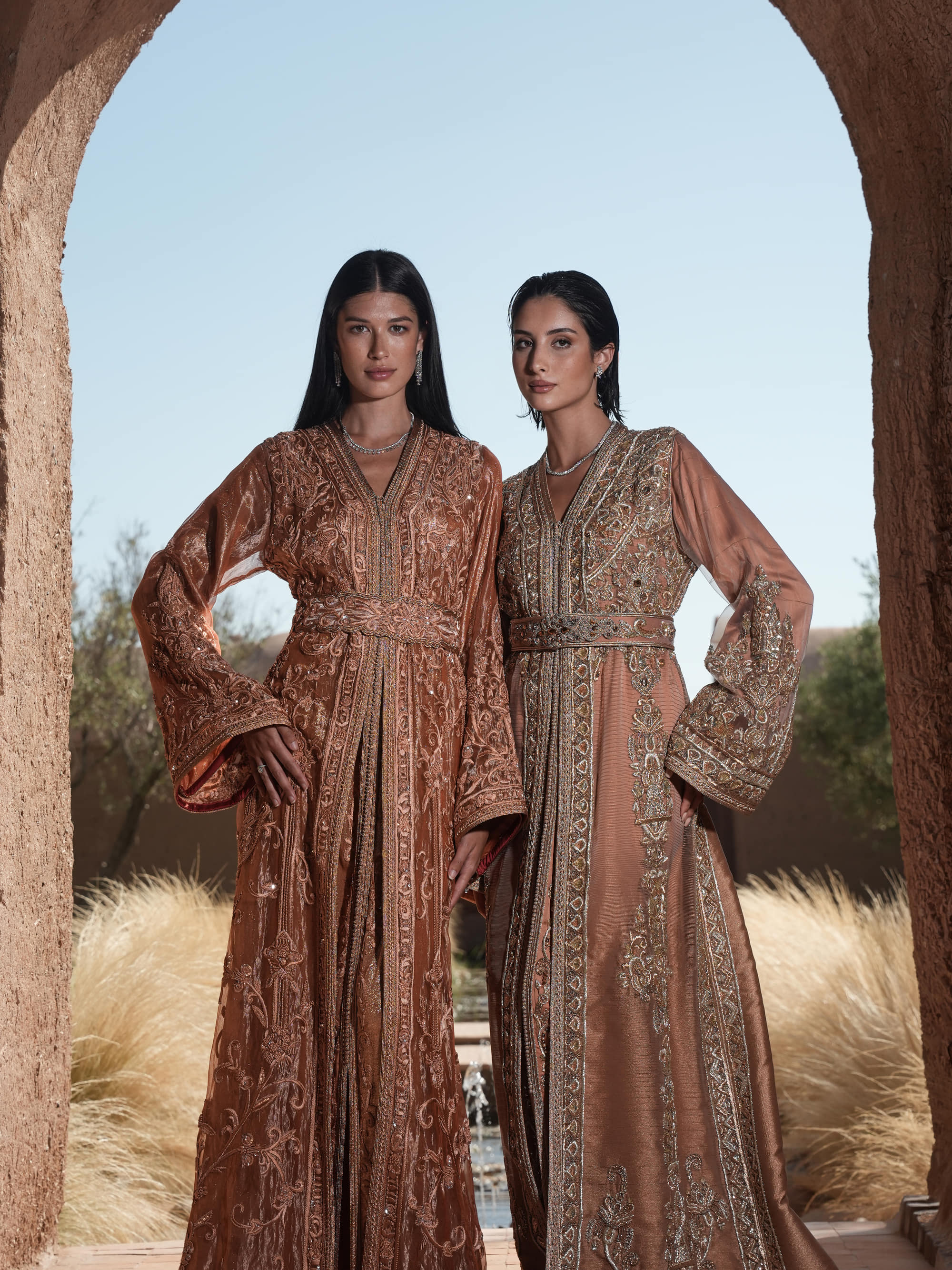 Rosewood Aurora copper-rose organza Moroccan kaftan with silver embroidery and jewelled belt, shown alongside a second look